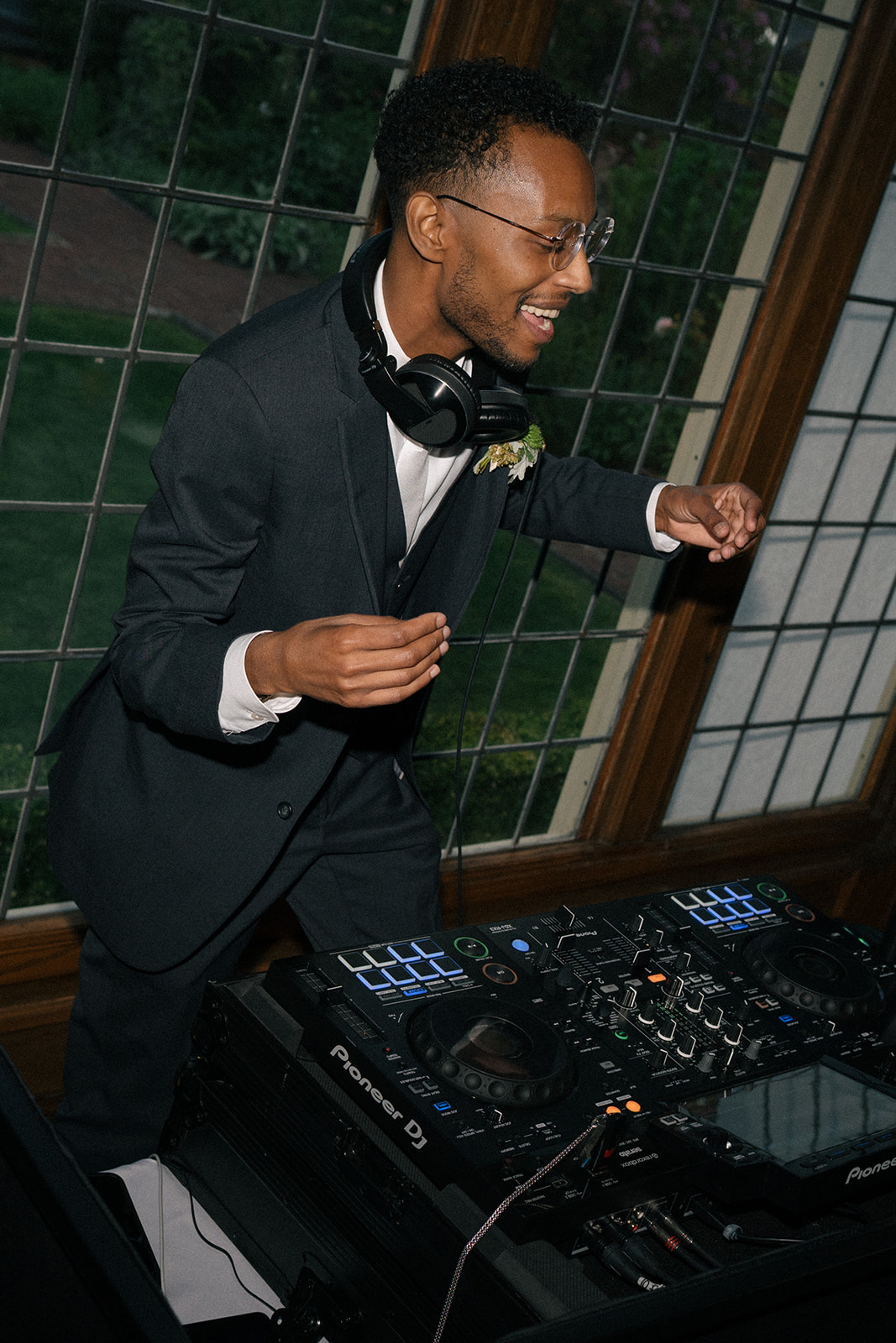 Groom DJing his own wedding reception while dancing behind the booth at Lairmont Manor