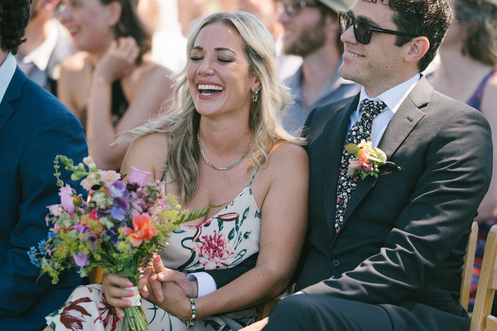 Candid laughter from a guest adds warmth to this Saltbox Barn wedding day. Let us document the real emotion of your celebration too.
