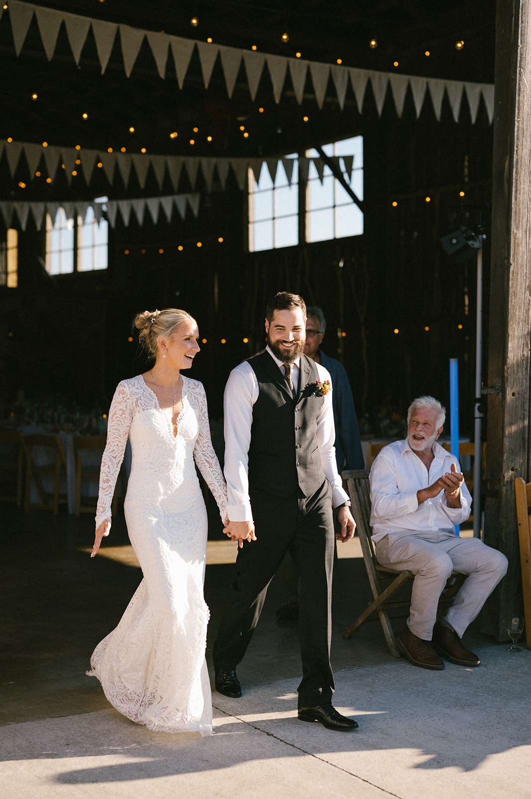 Newlyweds walk hand in hand toward the dance floor
