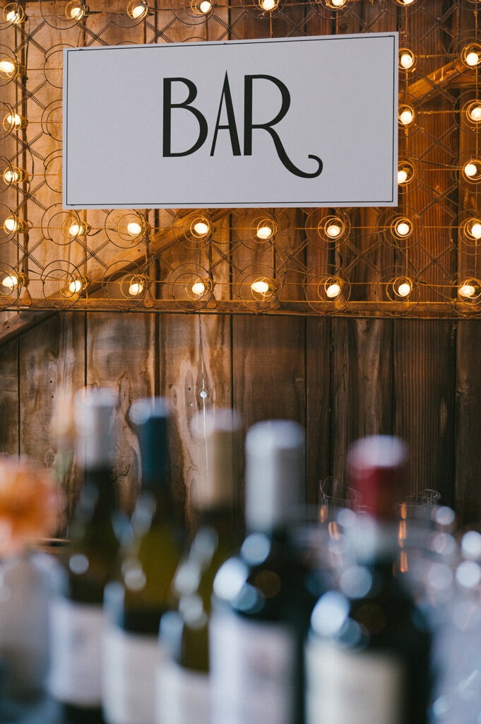 String lights frame the bar at this Saltbox Barn wedding reception