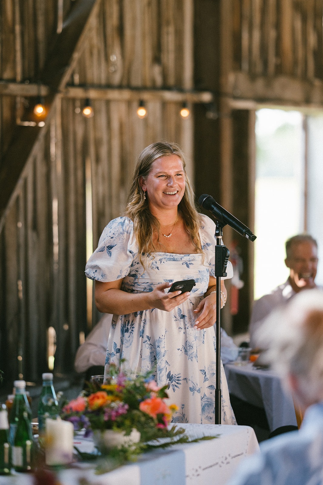 A friend gives a heartfelt toast during this Saltbox Barn wedding reception