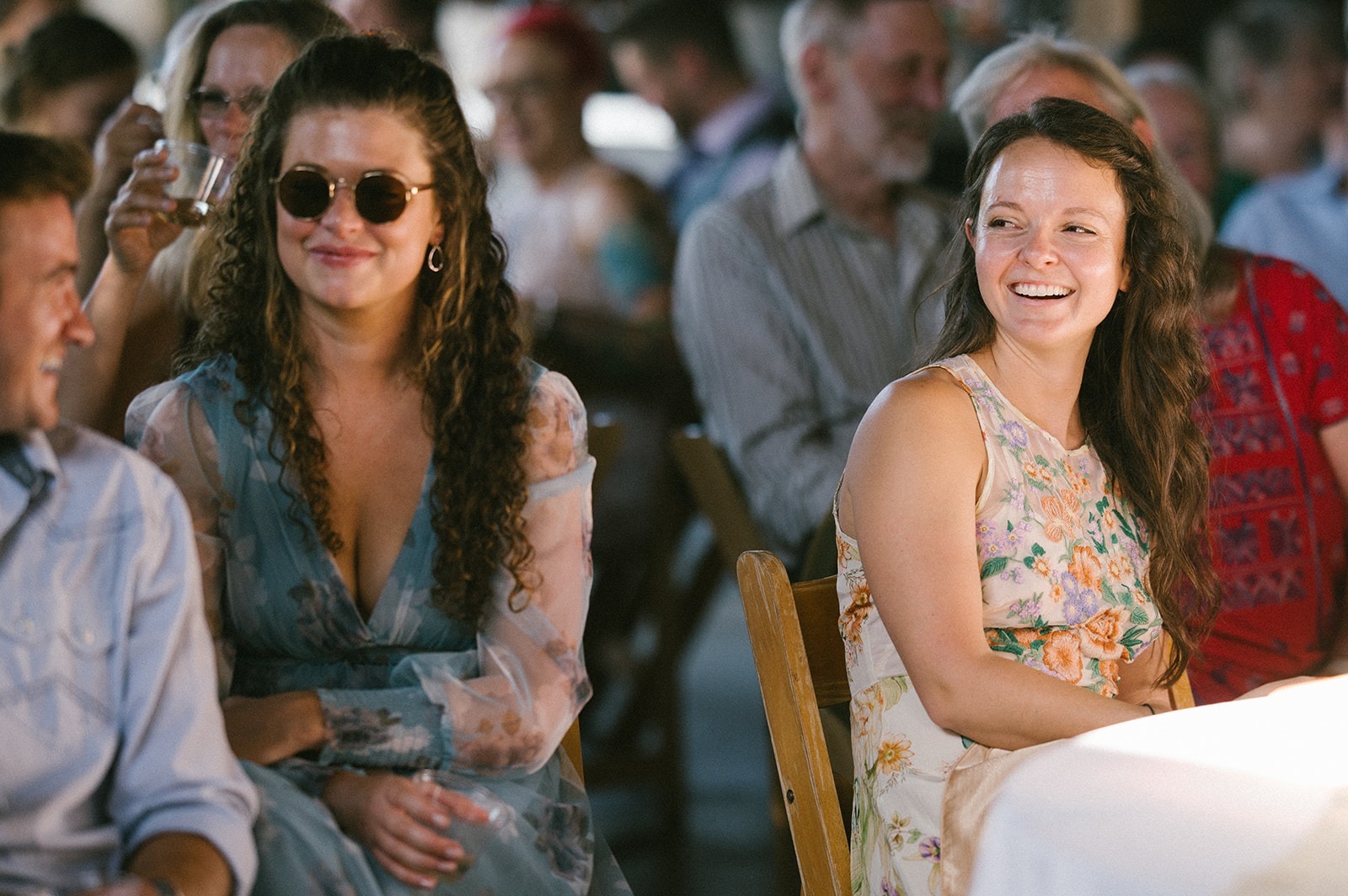 Guests laugh together during speeches at this Saltbox Barn wedding reception