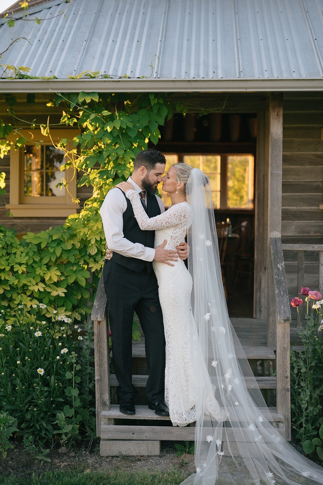 A quiet porch kiss captures the romance of this wedding at Saltbox Barn. Contact us to plan portraits full of genuine connection.