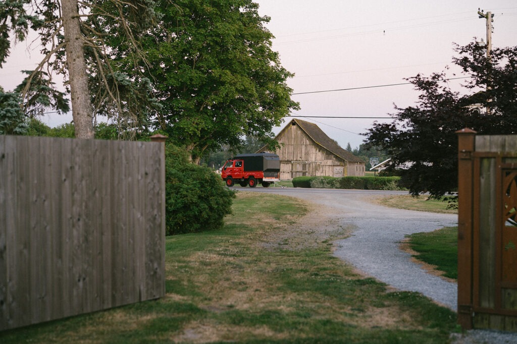 The couple's getaway truck drives away from their Saltbox Barn wedding reception