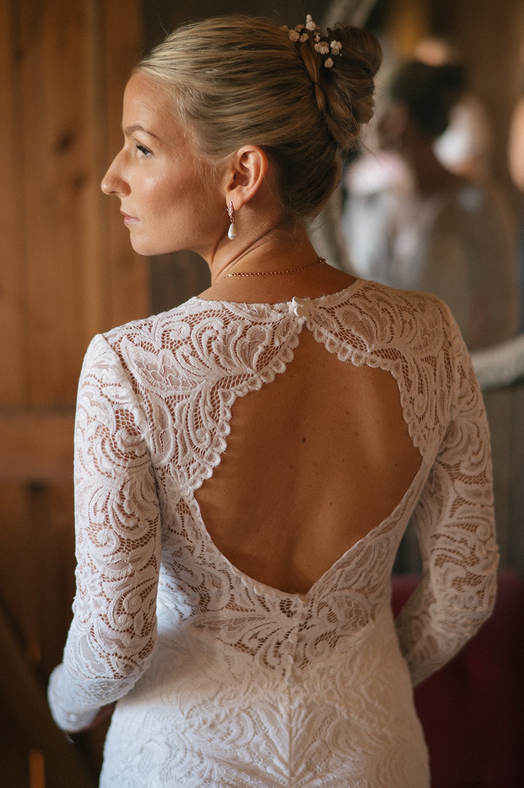 Detailed lace pattern shows across the open back of the bride's wedding gown