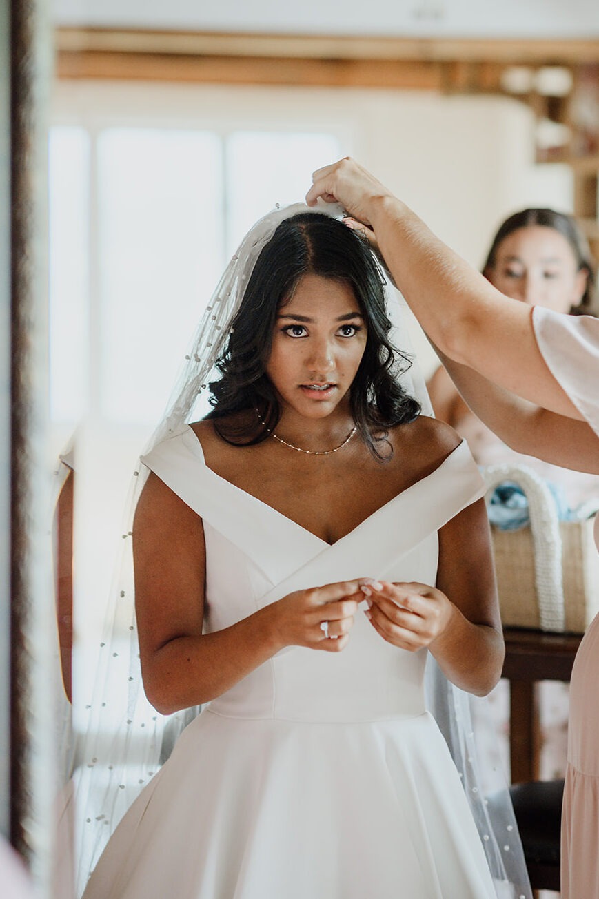 Bride getting ready as her veil is carefully placed before the ceremony
