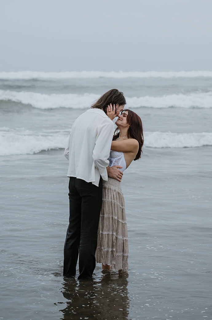 Couple embracing in the shallow waves on the Oregon coast