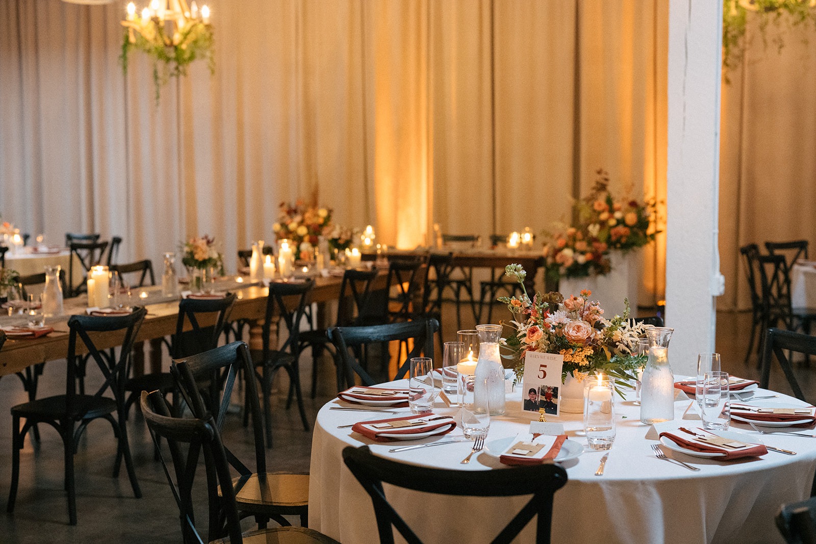 Long reception tables with layered place settings and candles