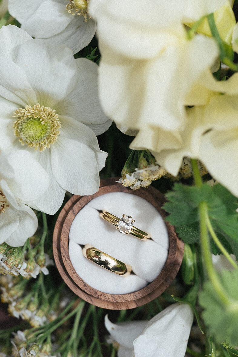 Wedding rings styled in white florals at Lairmont Manor in Bellingham Washington