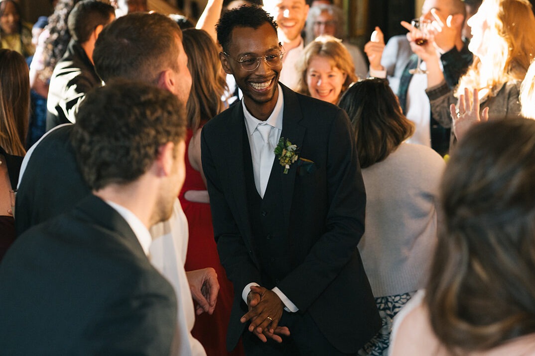 Guests crowd the dance floor celebrating with the groom during a lively reception at Lairmont Manor