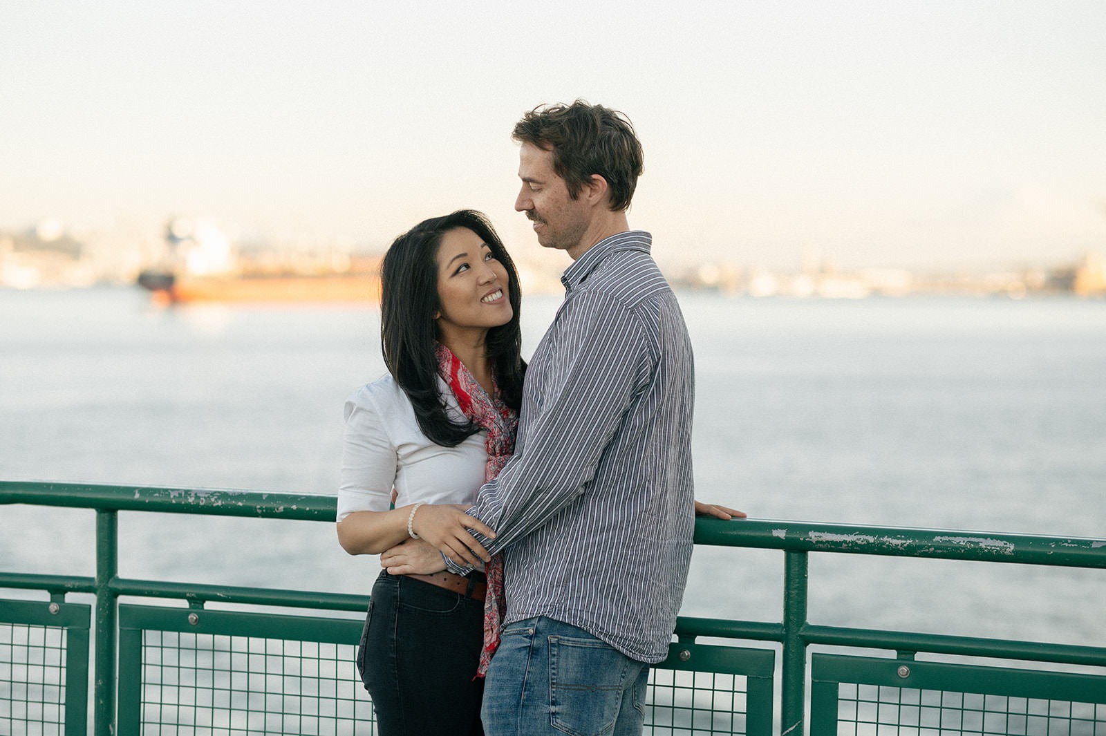 Couple standing together by the ferry railing during a Washington State Ferry engagement session