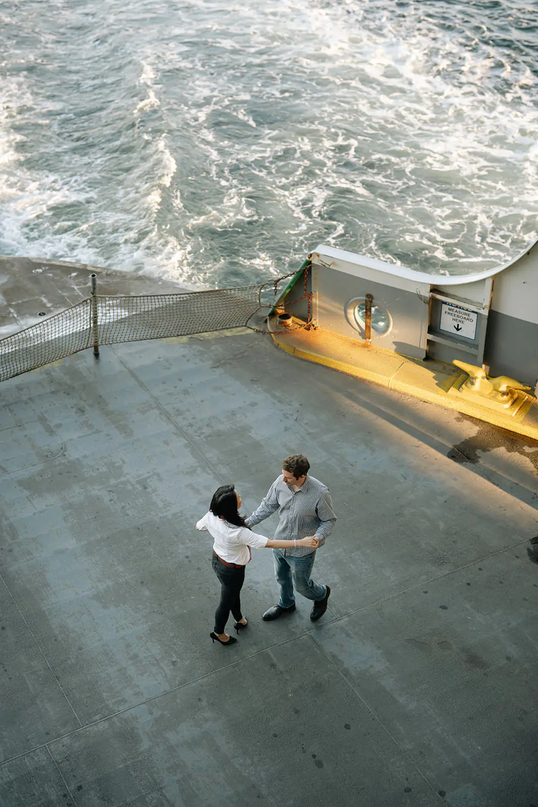 Overhead photo of a couple spinning together on the back of a Washington State Ferry