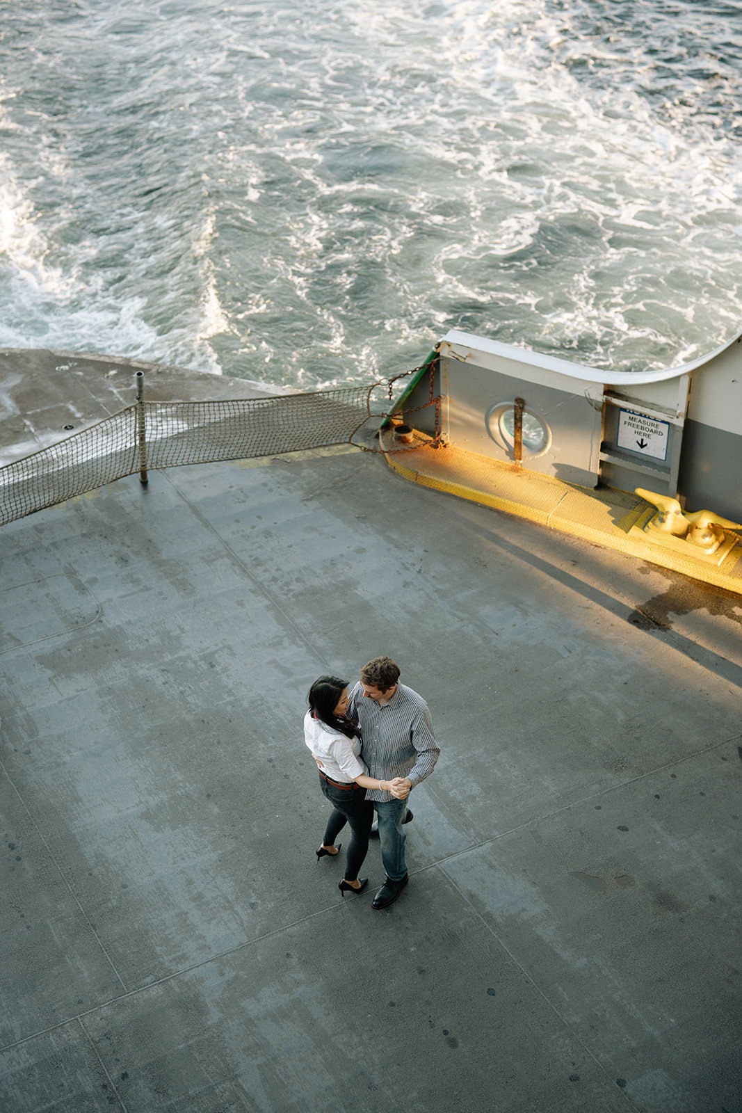 Overhead photo of a couple dancing together on the ferry deck above the water