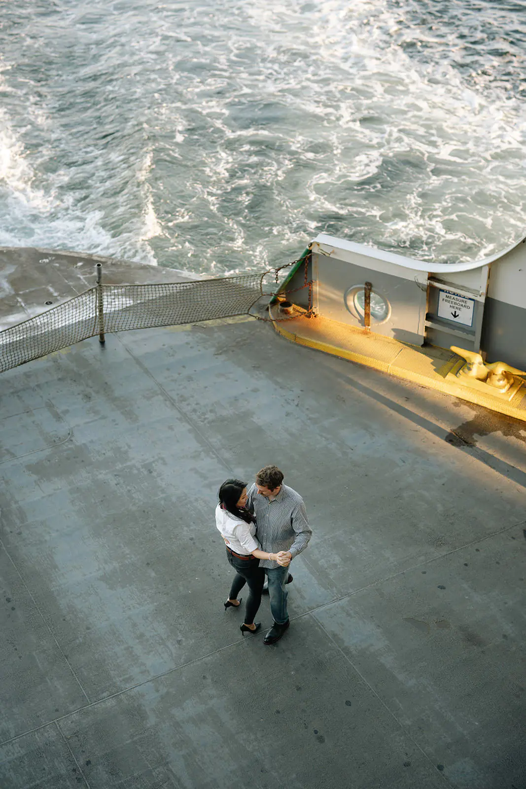 Overhead photo of a couple dancing together on the ferry deck above the water