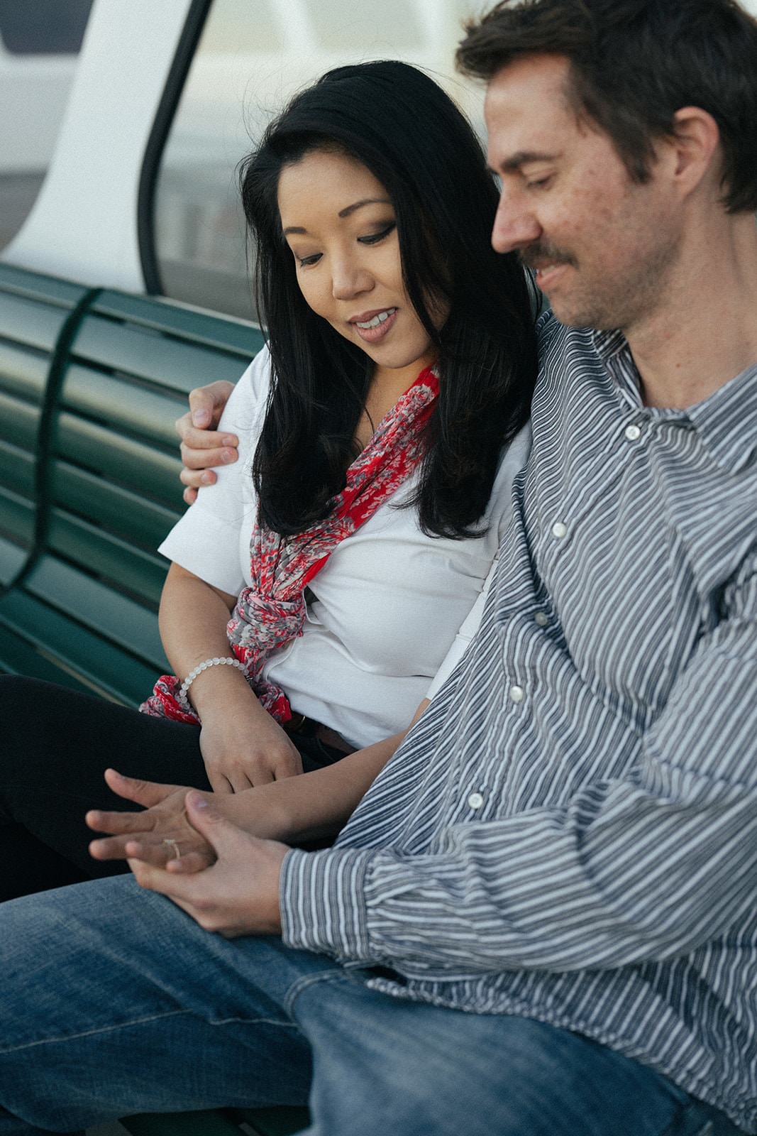 Couple sitting together on a ferry bench during a Seattle engagement session