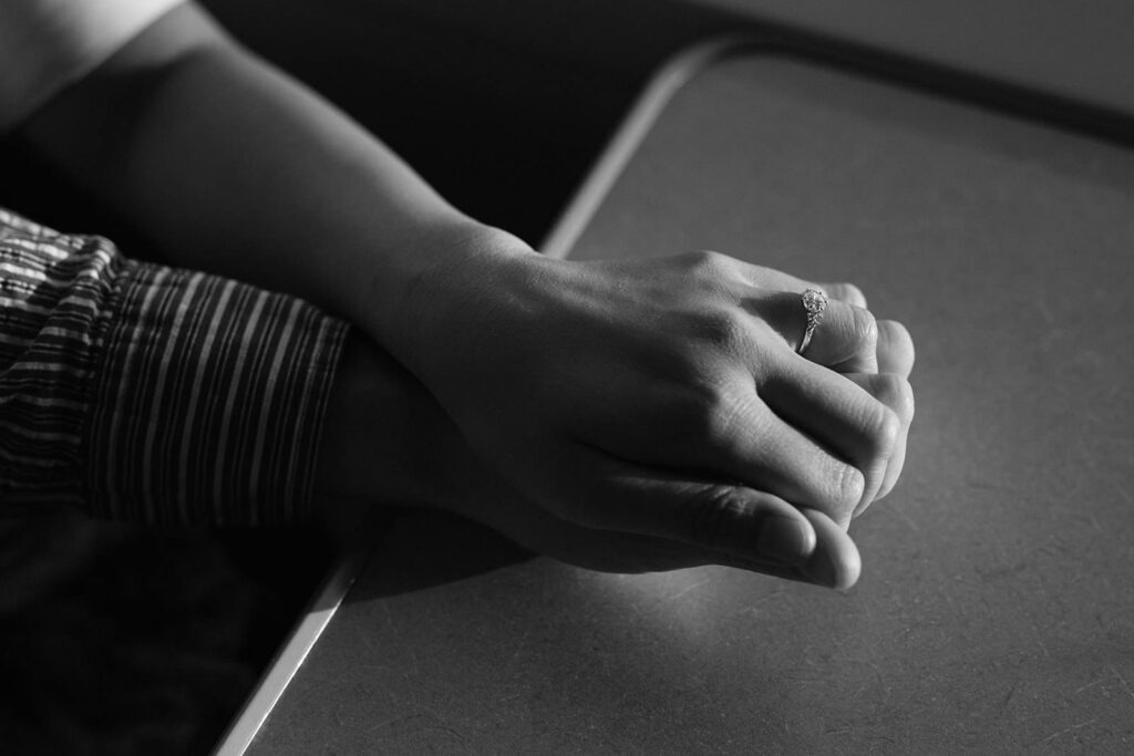 Close up of a couple holding hands on a ferry table during an engagement session