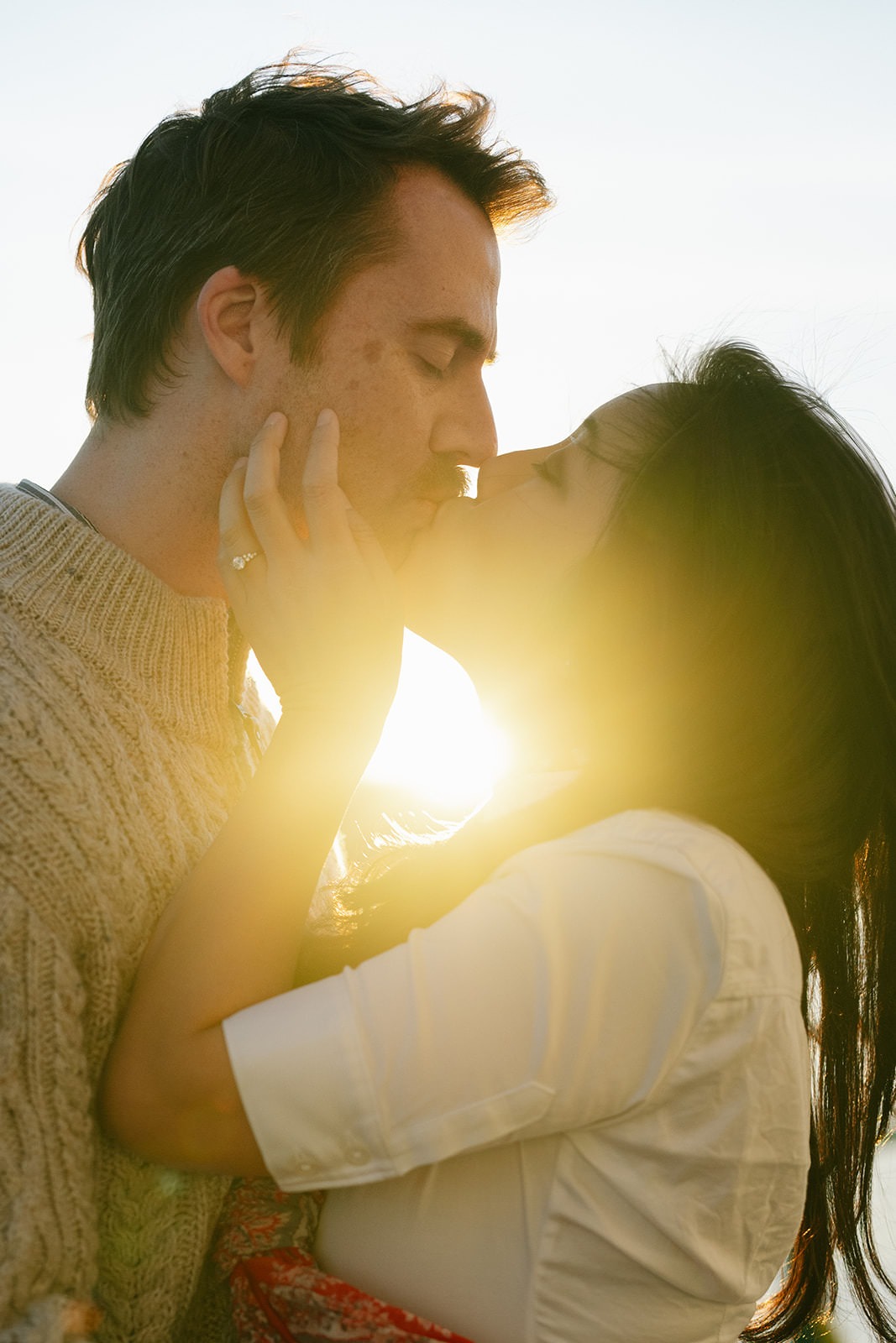 Close up of a couple kissing with golden sunlight during a Seattle ferry engagement session