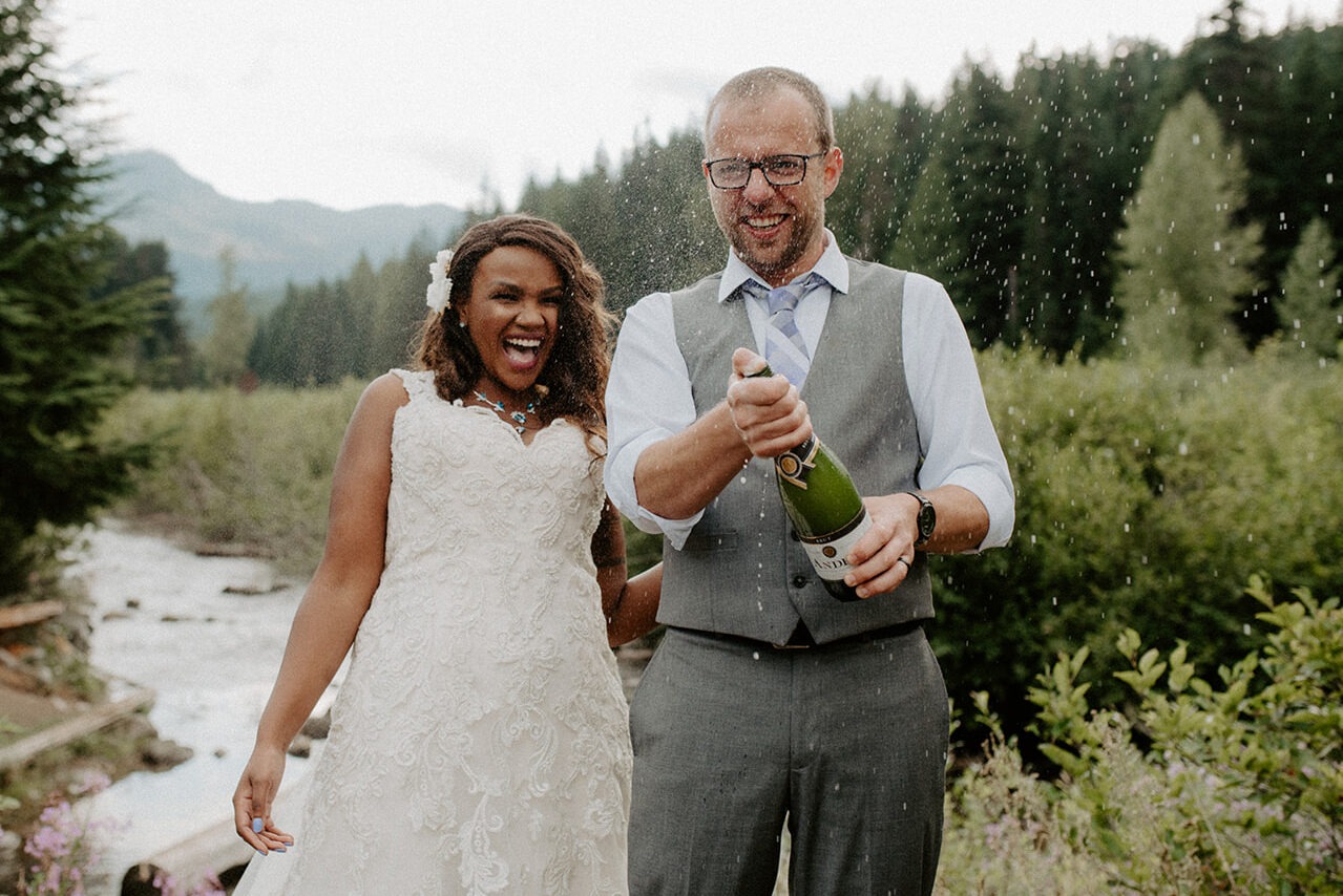 Joyful champagne pop celebration after an intimate Gold Creek Pond elopement ceremony