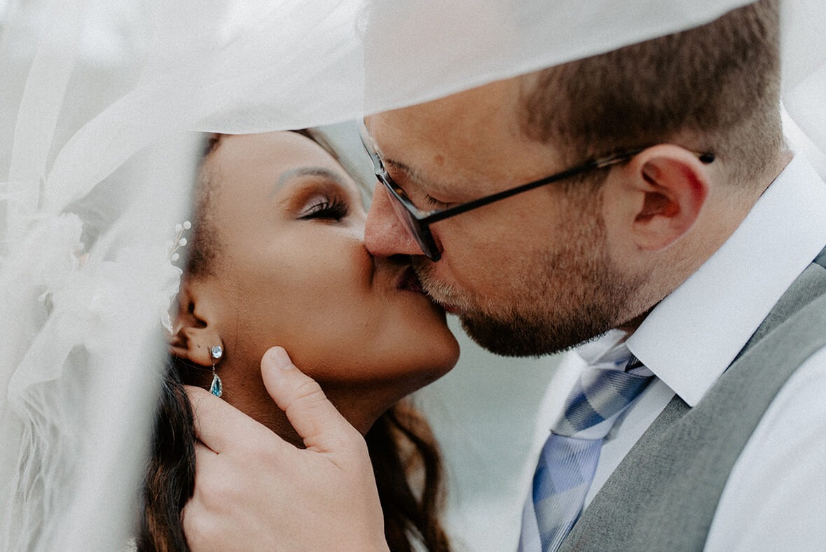 Tender kiss under the veil at an intimate Cascade Mountains elopement at Gold Creek Pond