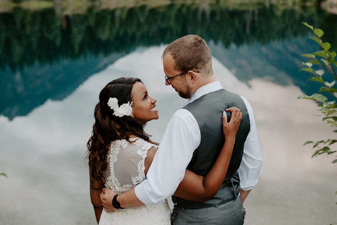 Intimate Pacific Northwest elopement portrait at Gold Creek Pond with mountain reflections in the alpine water