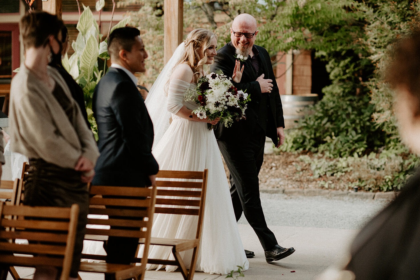 Bride walking down the aisle with her father during the wedding processional at Willows Lodge, both smiling