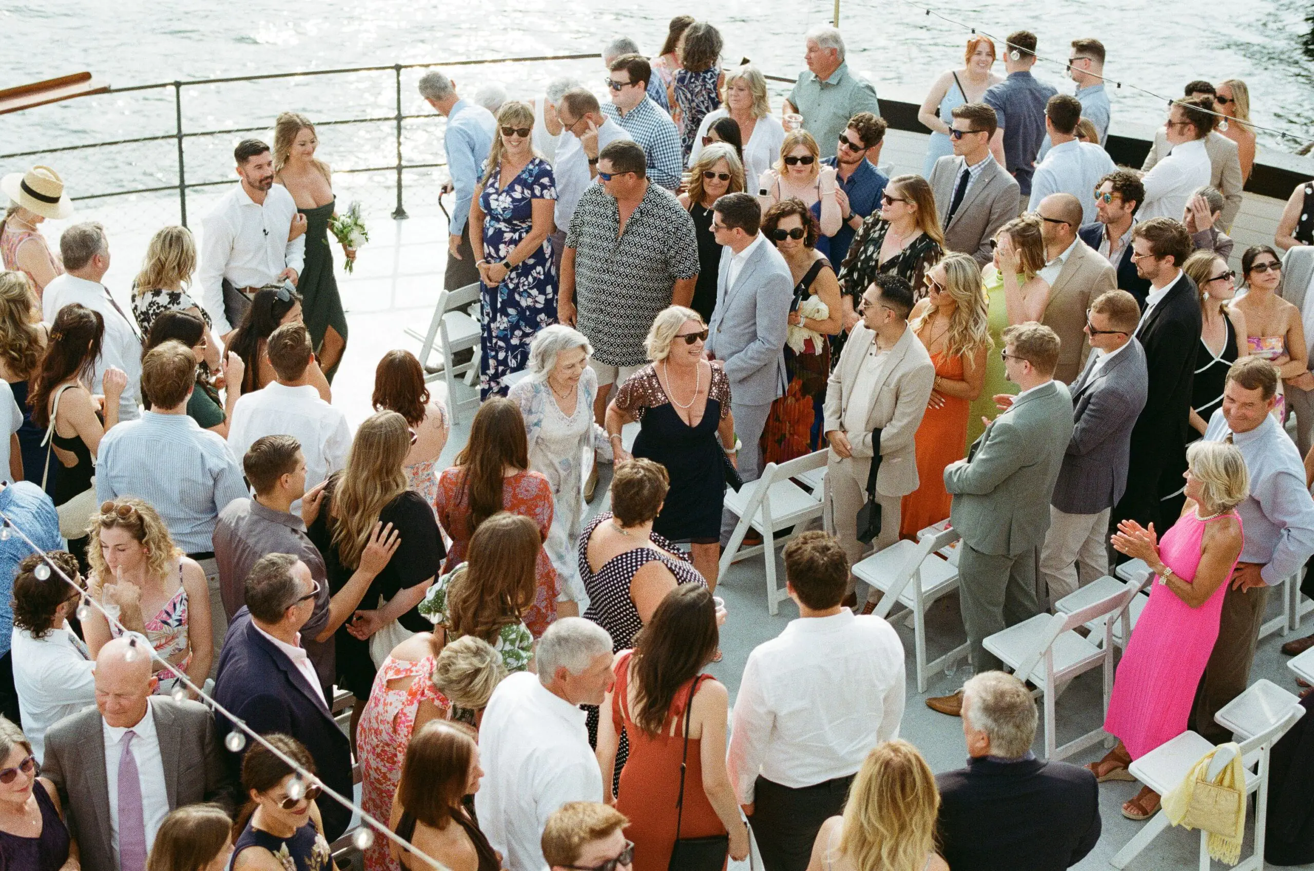 Aerial view of wedding guests mingling on the bow of MV Skansonia after the ceremony on Lake Union