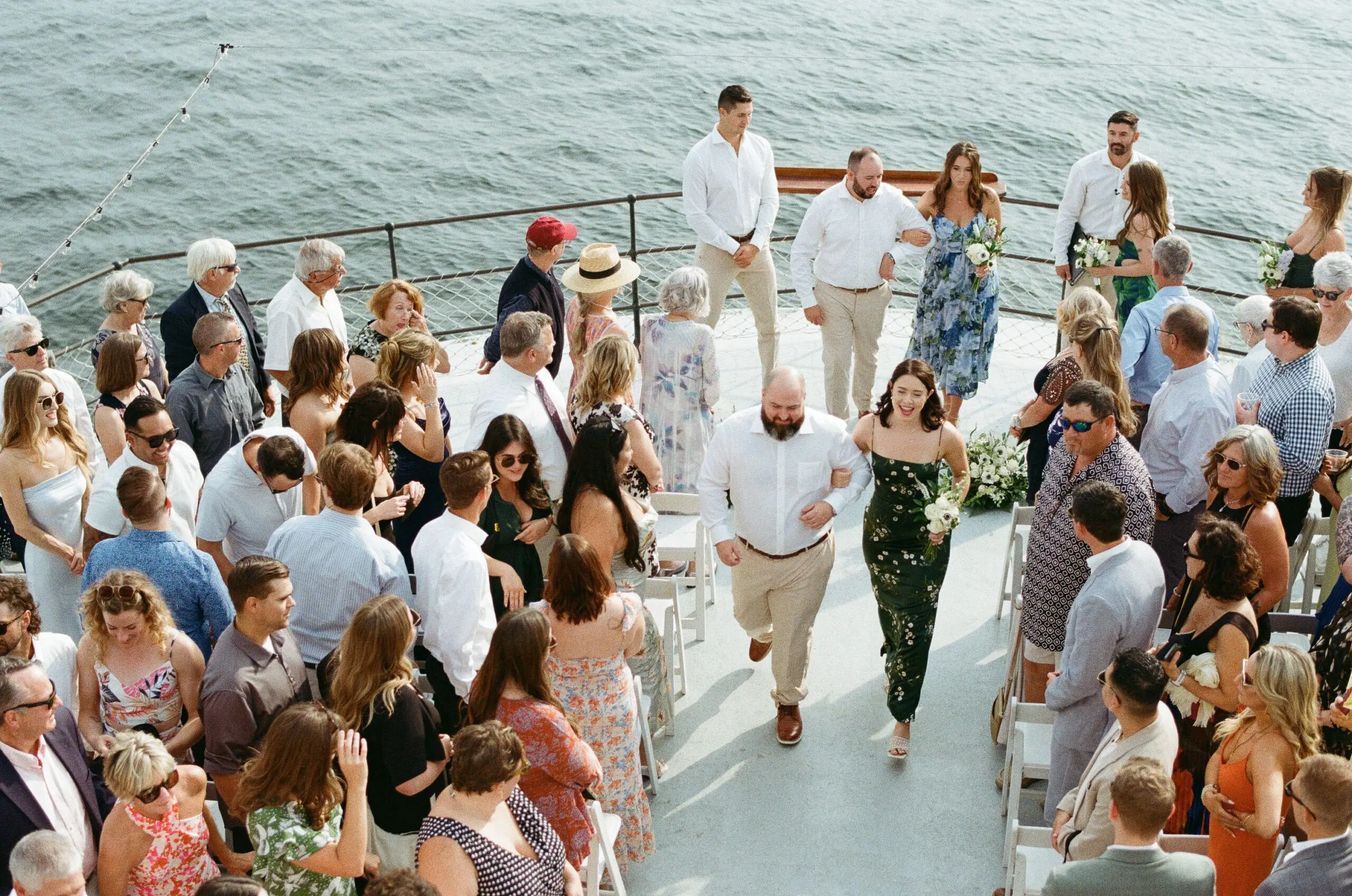 Wedding party recessional on the bow of MV Skansonia with guests cheering on both sides and Lake Union behind them