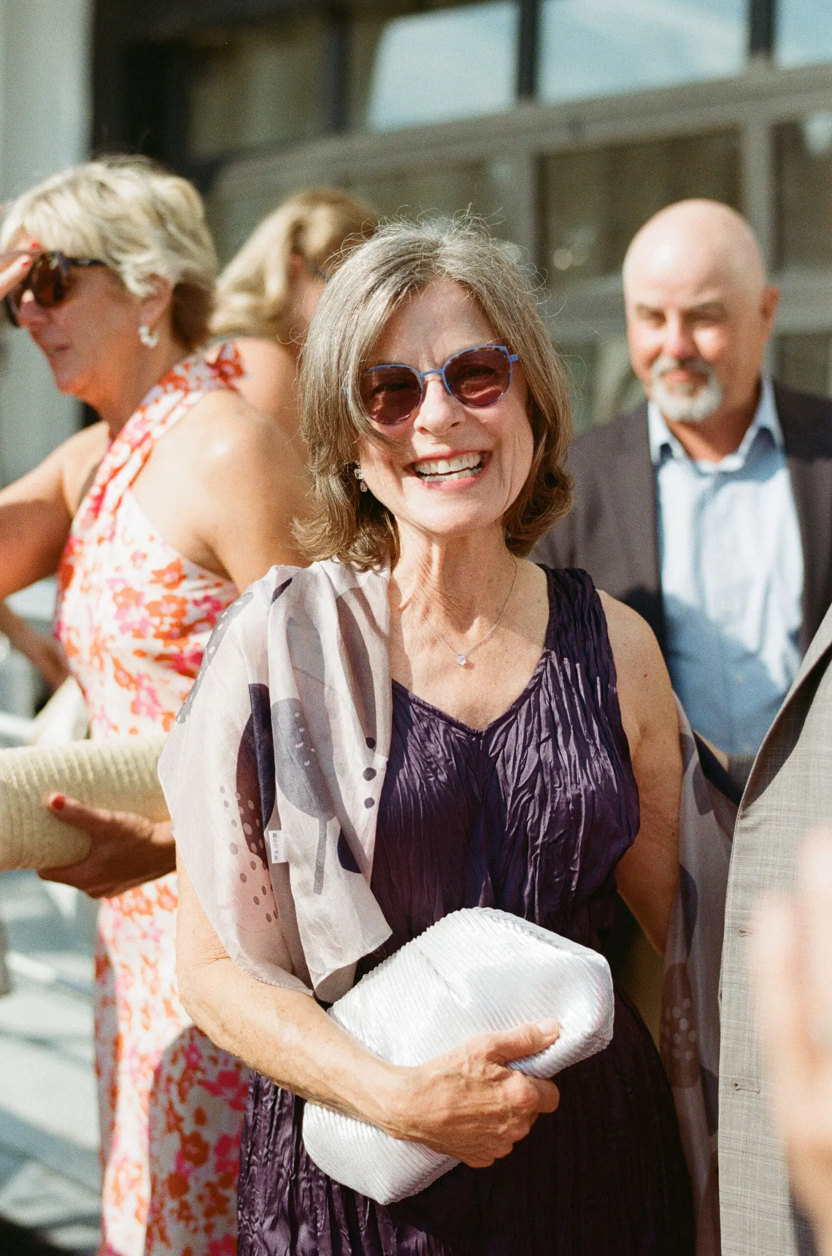 Wedding guest smiling in sunglasses on the deck of MV Skansonia at a Seattle waterfront wedding