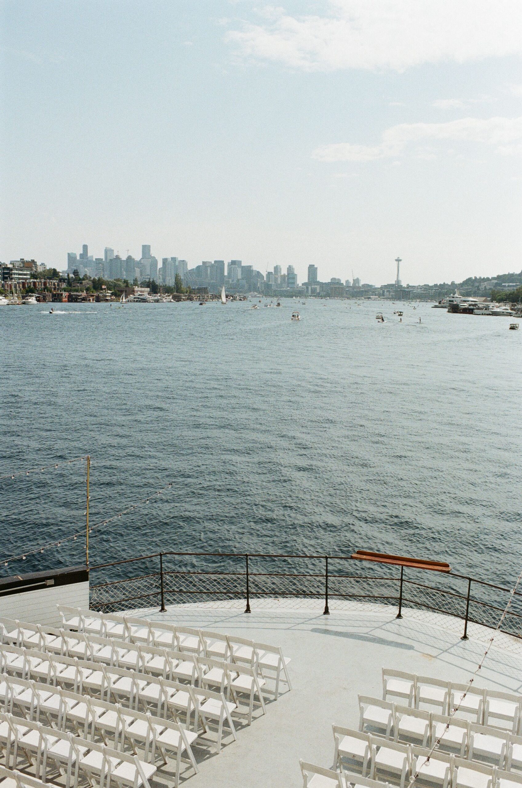 Wedding ceremony chairs set up on the bow of MV Skansonia with Lake Union and the Seattle skyline behind the altar