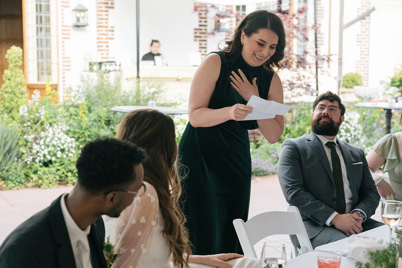 Wedding guest giving a heartfelt speech during outdoor tent reception at Lairmont Manor