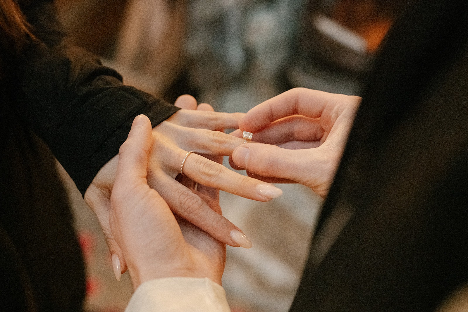 Close-up of the engagement ring being placed on her finger during a candlelit cabin proposal in Granite Falls