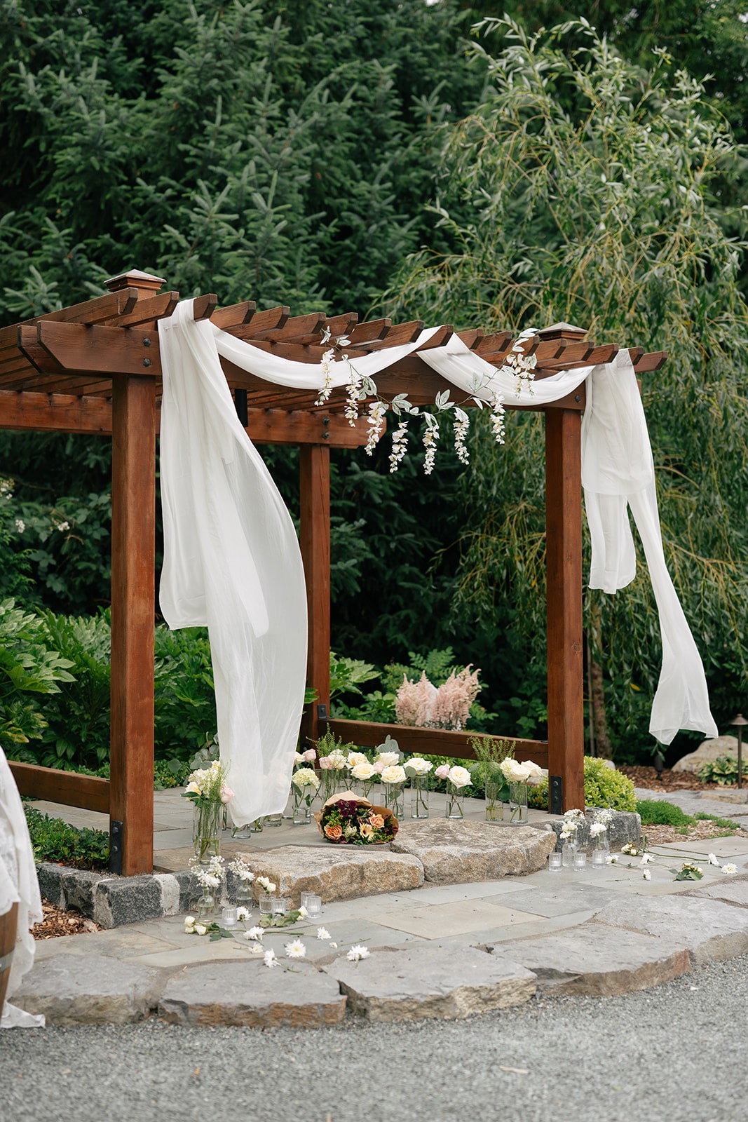 White draped arch adorned with wisteria and white roses for a Willows Lodge proposal in Woodinville