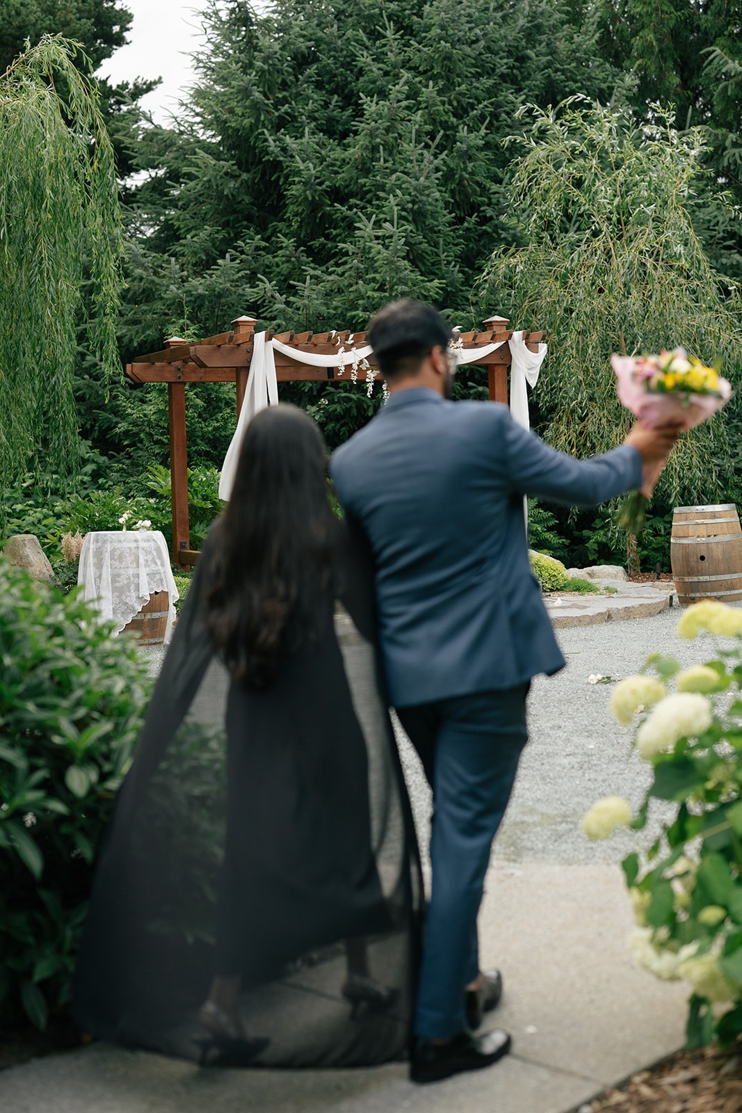 Piyush leads Priyanka toward the decorated proposal arch at Willows Lodge in Woodinville, WA, moments before the surprise