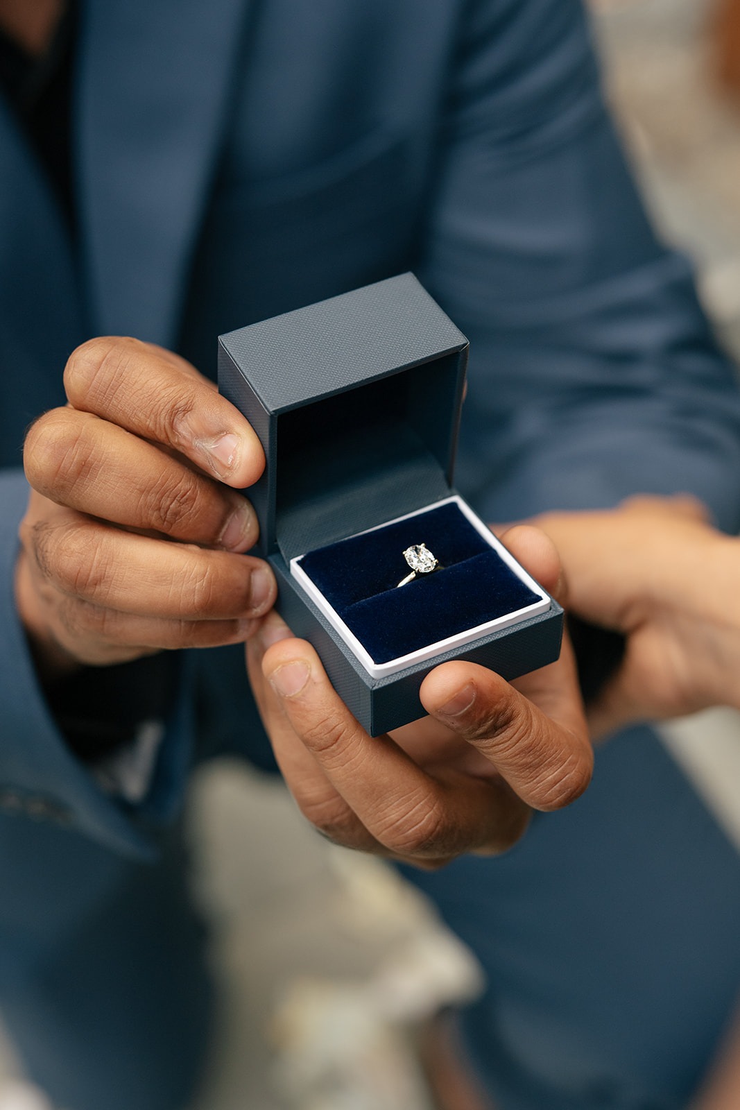 Solitaire diamond engagement ring in a navy velvet box at a Willows Lodge surprise proposal