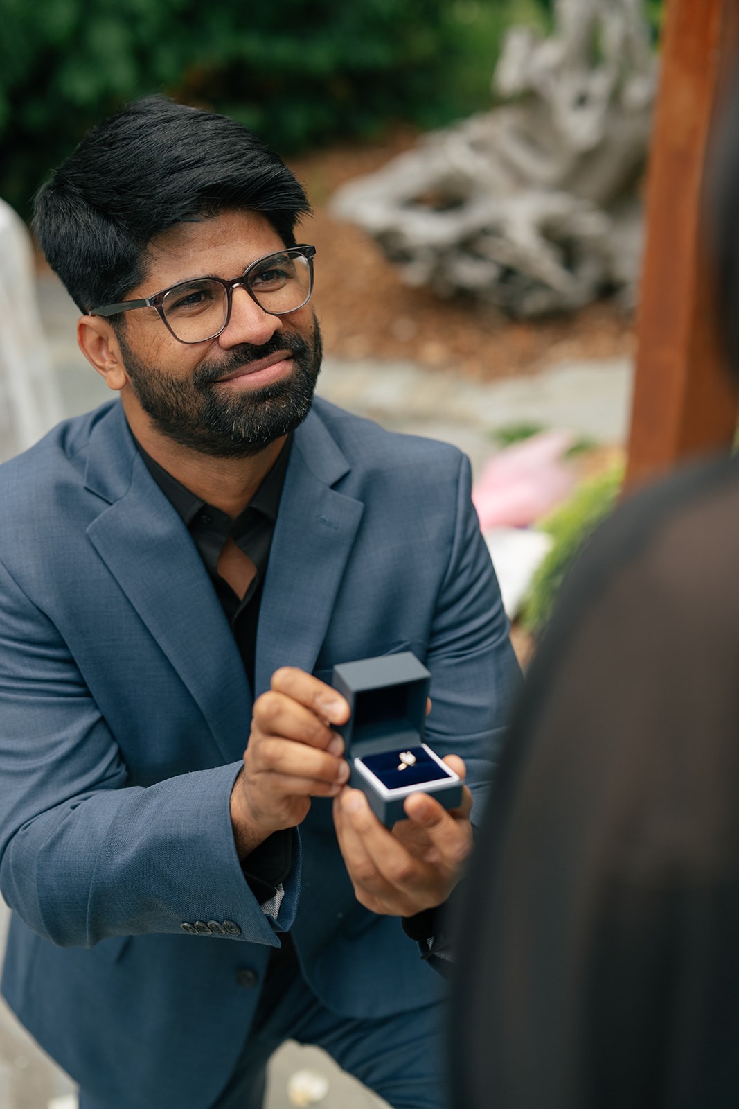 Piyush smiles as he holds the open engagement ring box just before proposing at Willows Lodge