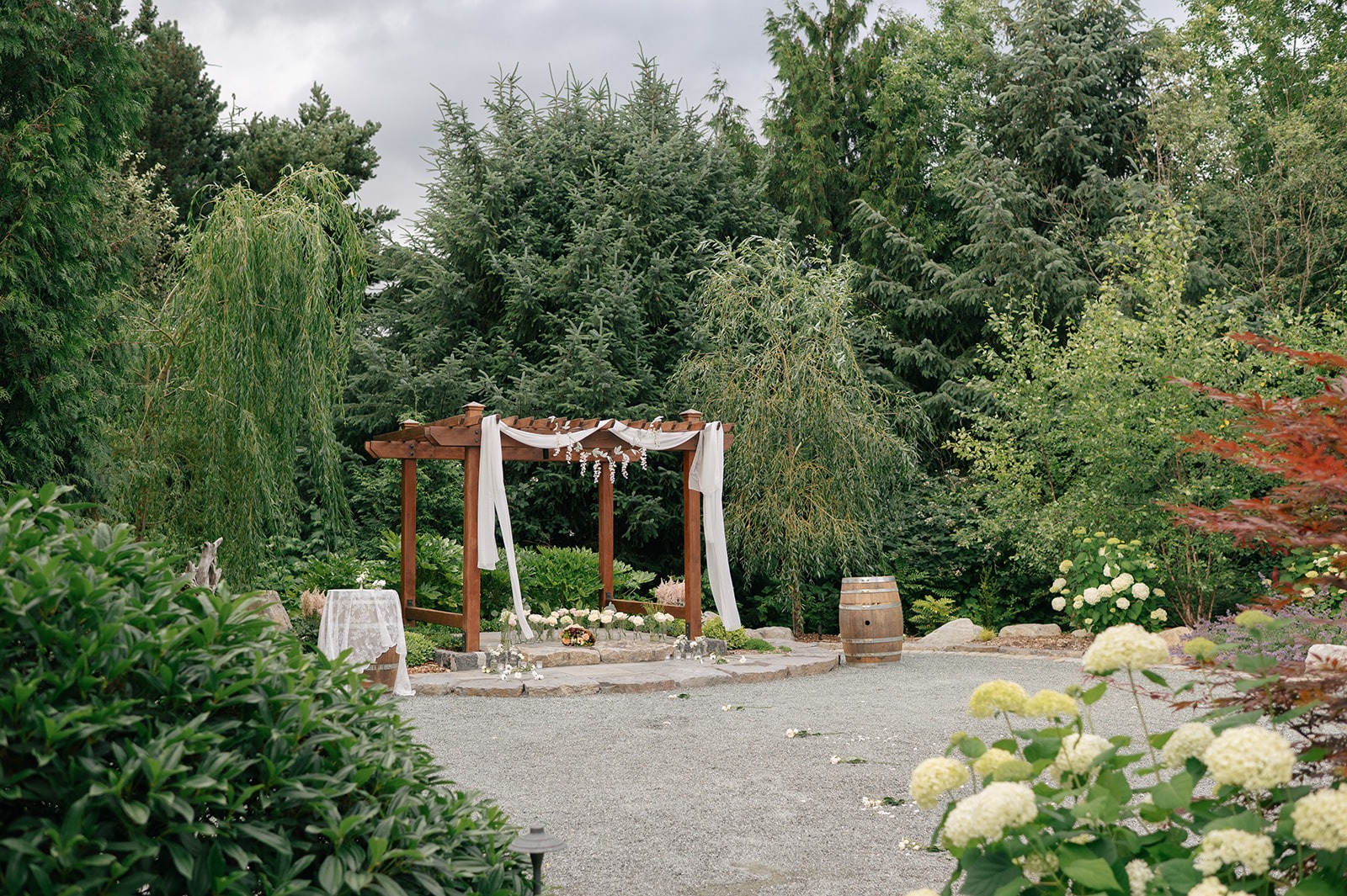 Decorated wooden arch with white drapery and florals set up for a surprise proposal at Willows Lodge in Woodinville, WA