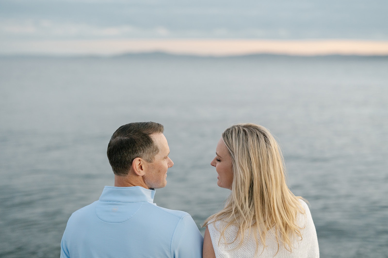 Couple stands close together on the beach as this Seattle engagement session winds toward sunset