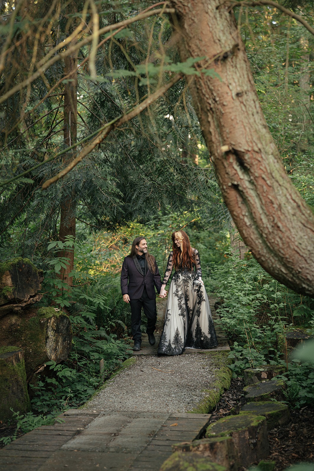 A quiet moment from this moody forest wedding portraits session beneath a large tree on the path