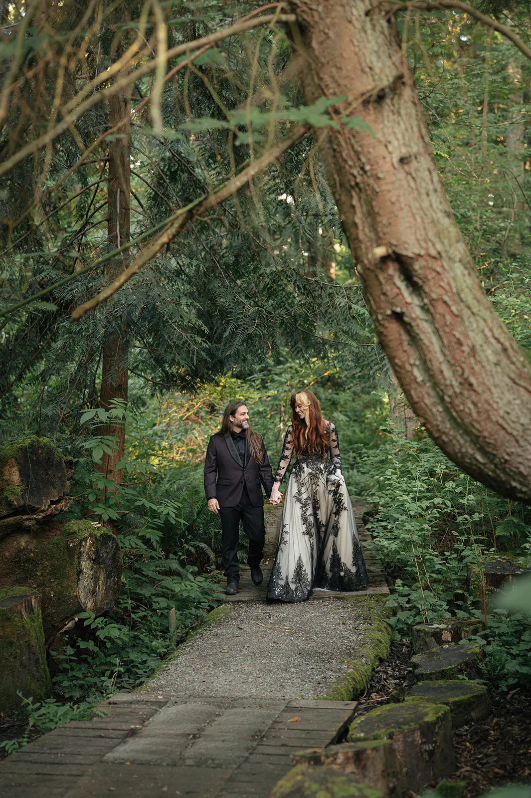 A quiet moment from this moody forest wedding portraits session beneath a large tree on the path