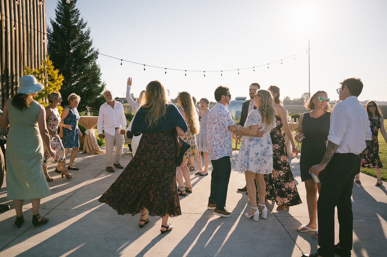 Guests form a line and dance together across the patio
